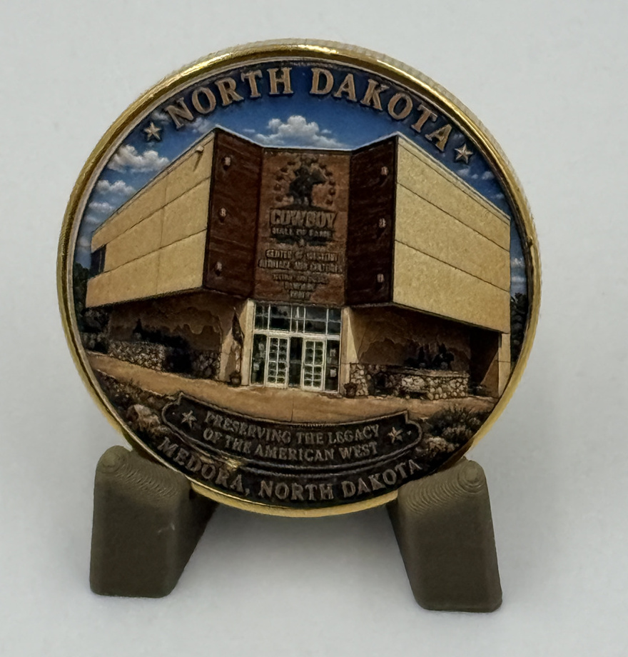 North Dakota Cowboy Hall of Fame building coin on its display stand