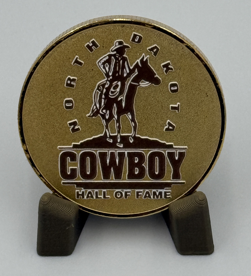 North Dakota Cowboy Hall of Fame emblem coin on its display stand