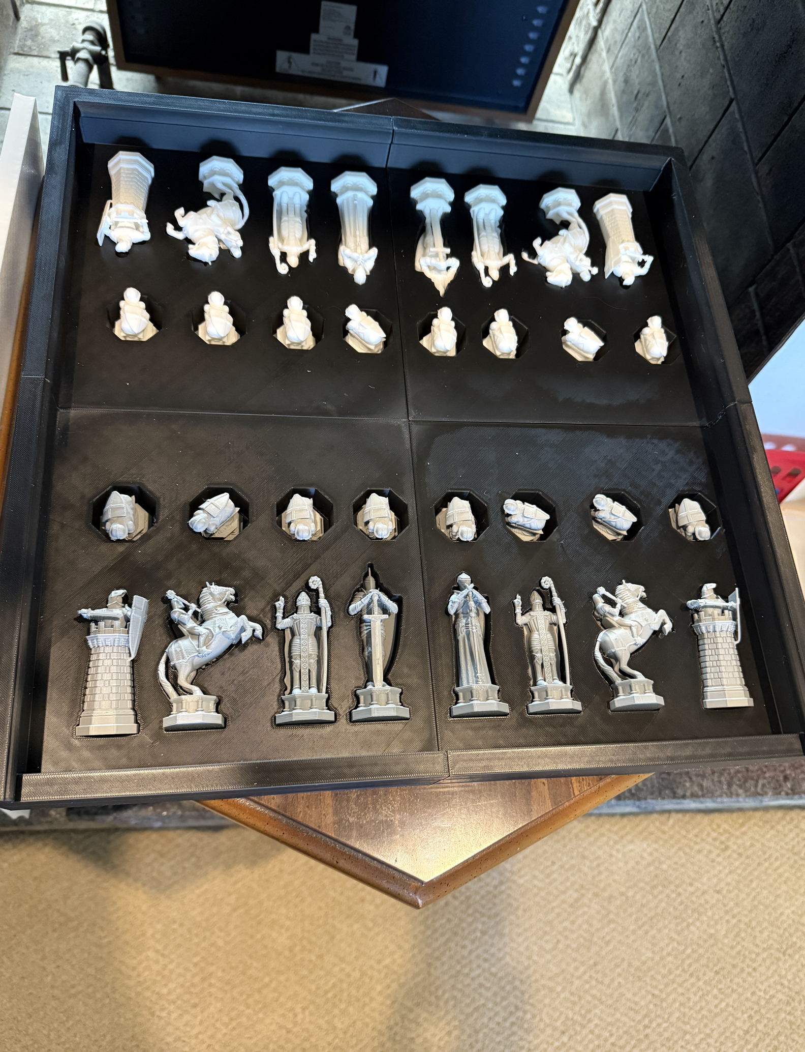 Custom chess pieces arranged in their fitted storage case