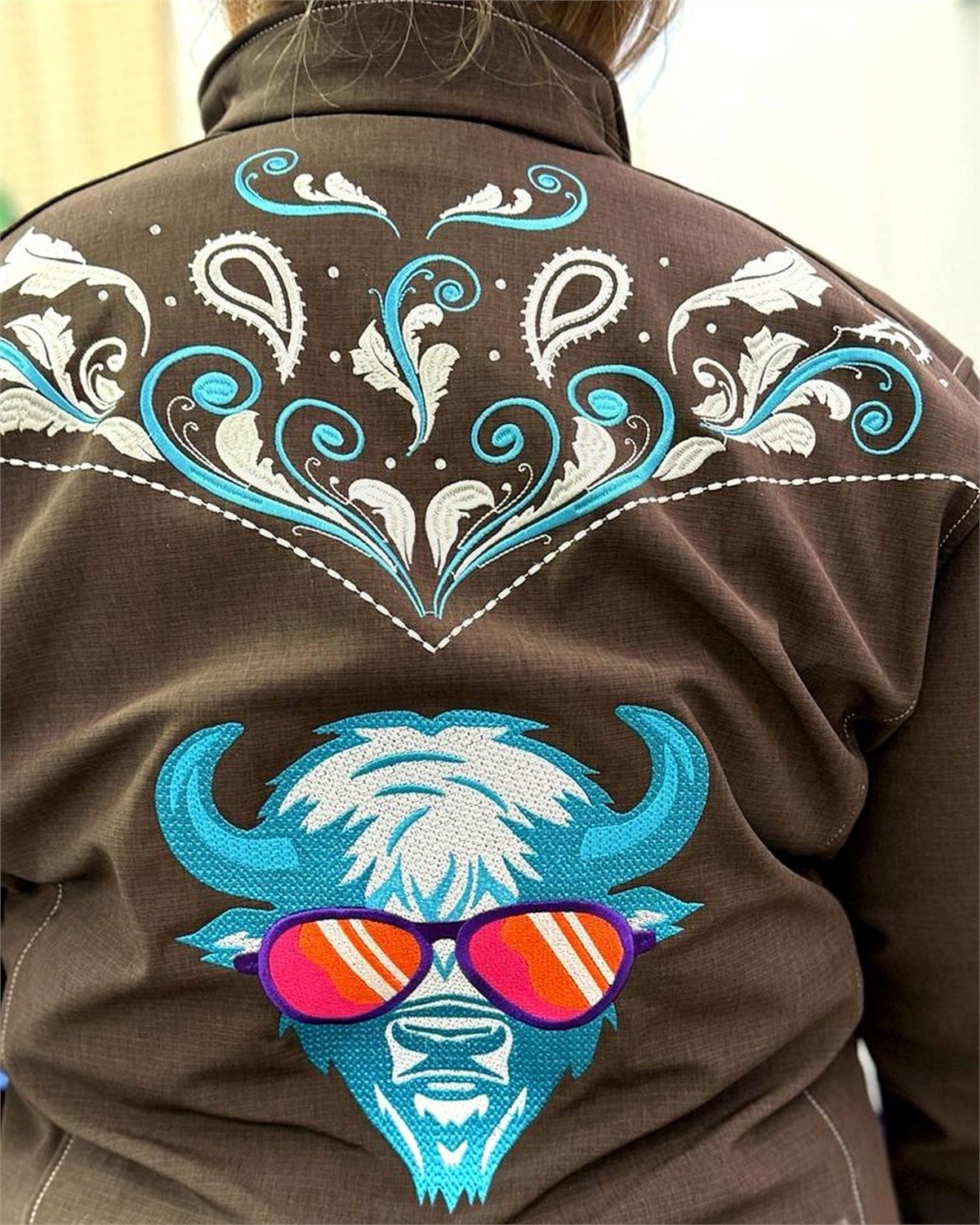 Buffalo embroidery added below existing decorative stitching on western apparel